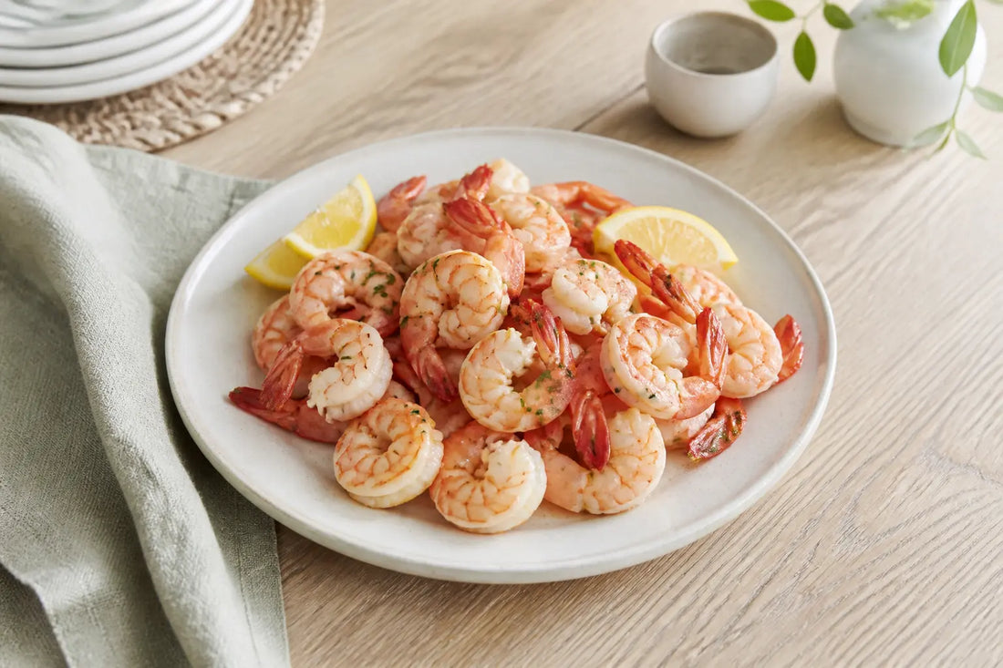 Assiette de crevettes cuites avec quartiers de citron sur table de cuisine, crevette enceinte en gros plan