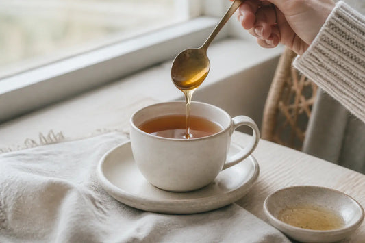Cuillère de miel dans une tasse de thé sur table de cuisine, illustration du miel enceinte en douceur naturelle