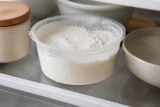 Ricotta enceinte dans un réfrigérateur, pot ouvert de ricotta pasteurisée en gros plan, lumière douce naturelle.
