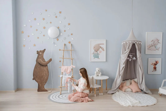 Chambre d'enfant aux murs bleu pâle avec ciel de lit, petite table et étoiles décoratives au mur