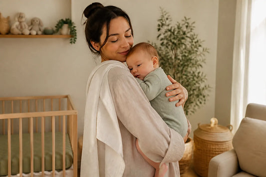 Maman berçant tendrement son bébé contre son épaule dans une chambre lumineuse