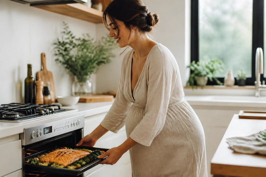 Femme enceinte préparant un saumon au four avec des légumes frais