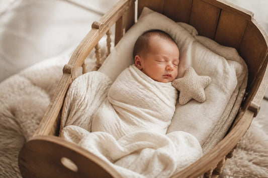 Nouveau-né endormi dans un berceau en bois, petit jouet étoile en tricot à côté